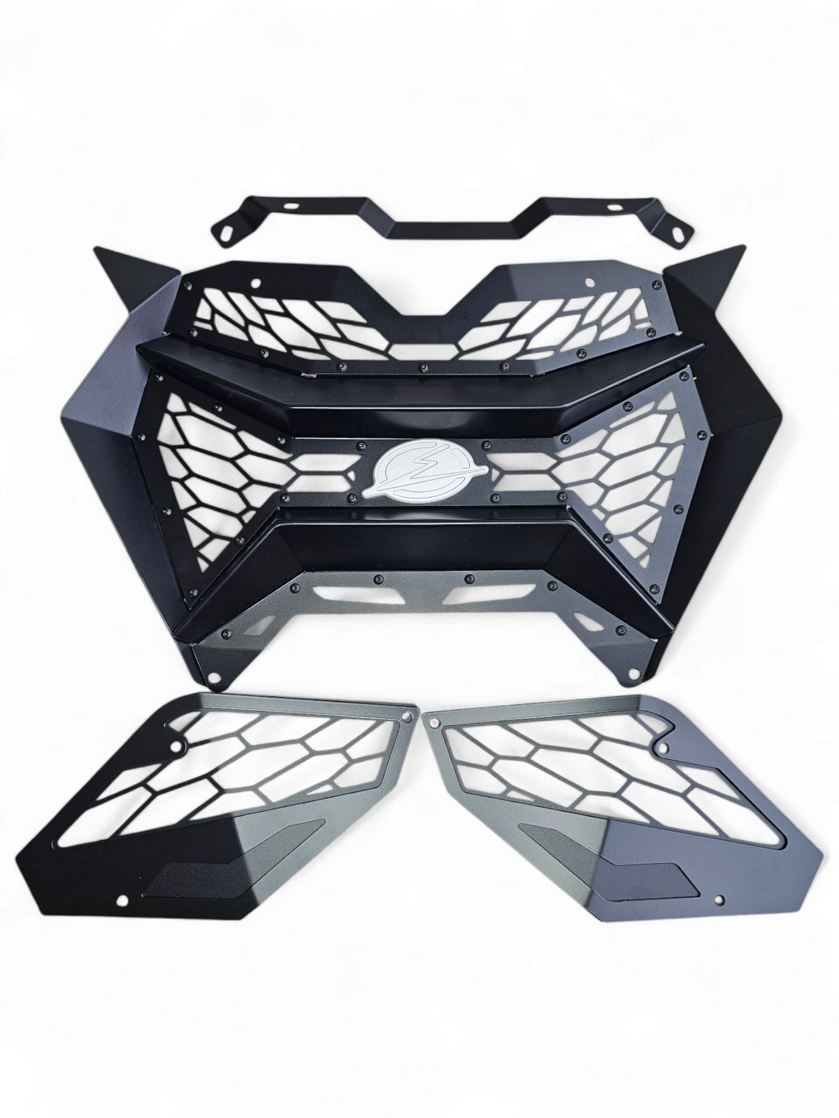 Volt 3-Piece Grille unboxed beside 2024 Can-Am Maverick R showing three grille
sections, billet badge, and complete bolt-in hardware kit